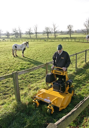 Wright stander I cutting grass beside paddock